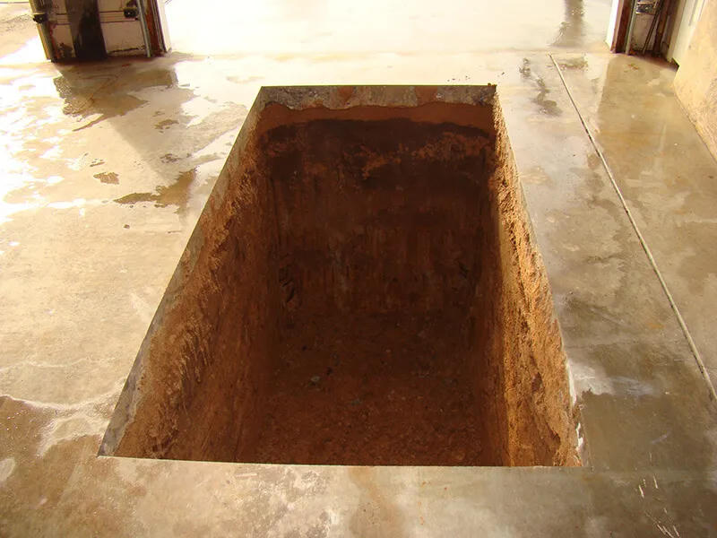 Excavated garage slab opening for shelter